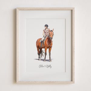 May include: A framed watercolour painting of a person riding a brown horse. The person is wearing a white shirt, black trousers, and a black helmet. The horse is wearing a brown bridle. The painting is titled "Chloe Dolly".