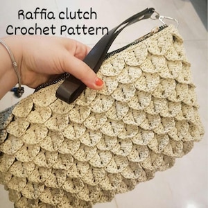 May include: A beige crochet clutch bag with a black strap and zipper closure. The bag is made with a woven raffia-like material and has a textured, scaly pattern. The text "Raffia clutch Crochet Pattern" is visible in the image.