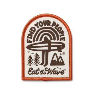 May include: A rectangular patch with an orange border features a brown illustration of a person surfing a rainbow wave. The text "FIND YOUR PEOPLE" arches above the surfer, and "Eat the Wave" is below. Two trees and a mountain are also depicted.