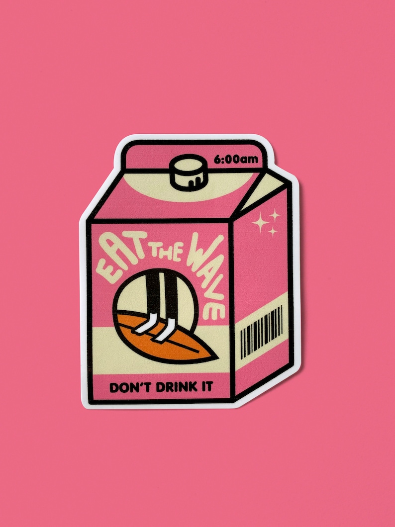 May include: Pink and beige milk carton sticker.  The sticker features the text 'EAT THE WAVE' in a stylized font, with an illustration of legs on a surfboard inside a circle.  The bottom of the sticker says 'DON'T DRINK IT'.  The top right corner shows '6:00am'.  A barcode is visible on the right side. The overall style is retro and playful.