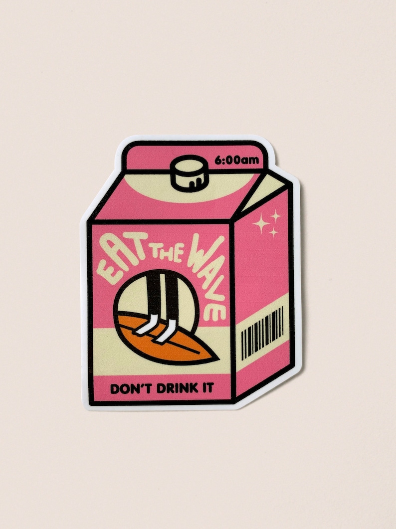 May include: Pink and beige milk carton sticker. The sticker features the text 'EAT THE WAVE' in a stylized font, with an illustration of legs on a surfboard inside a circular cutout.  The bottom of the carton reads 'DON'T DRINK IT'. The top right corner displays '6:00am'. A barcode is visible on the side. The overall design is playful and summery.