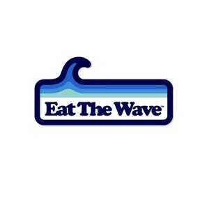 May include: A sticker with a navy blue border and a wave-shaped top. The design features a blue and white wave graphic above the text "Eat The Wave" in white, sans-serif font.