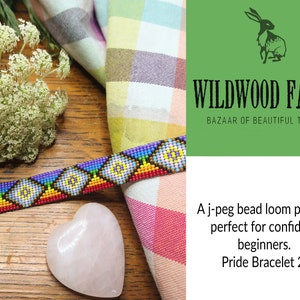 May include: A colorful beaded bracelet with a geometric pattern in shades of blue, purple, yellow, and red. The bracelet is displayed on a wooden surface with a heart-shaped stone and a patterned fabric. The image also features the text "Wildwood Fayre".