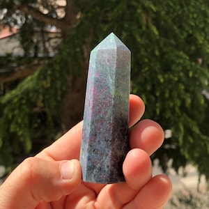 May include: A green and pink crystal point with a pointed tip. The crystal is smooth and polished.