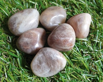 May include: Five tumbled sunstone stones in various shades of brown and white. The stones are smooth and polished, with a slight shimmer.