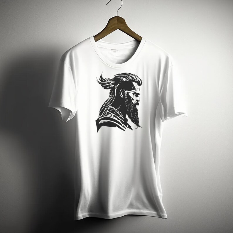 May include: White t-shirt with a black and white graphic of a man with a beard and long hair.