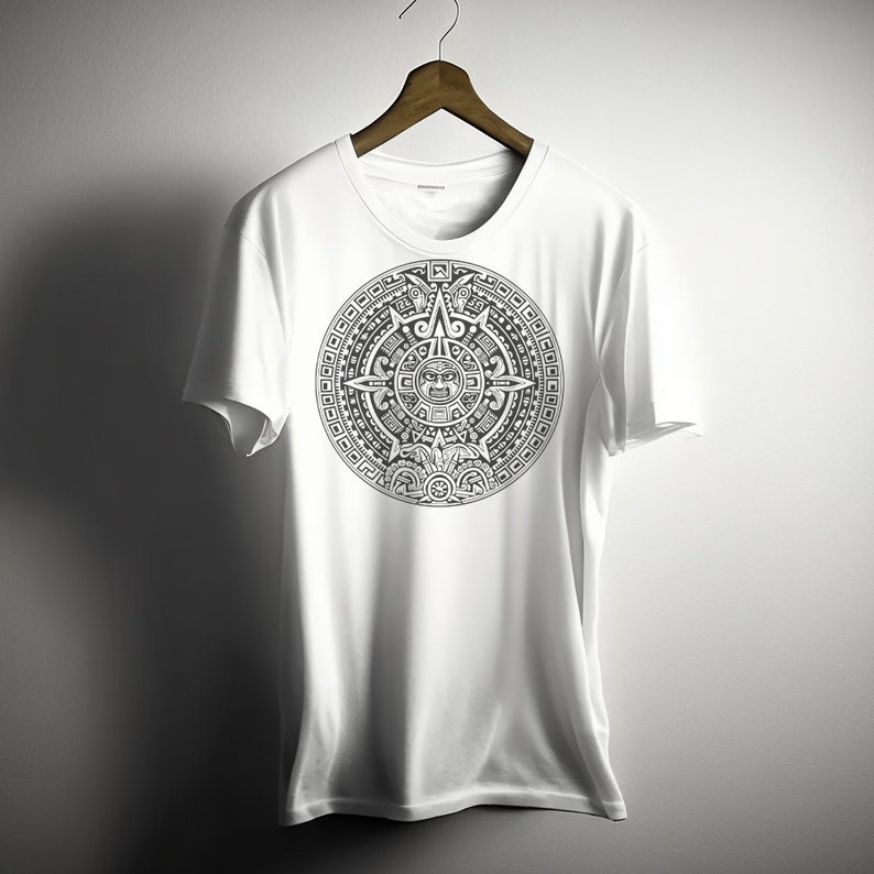 Puede incluir: Camiseta blanca con un estampado gr&aacute;fico en blanco y negro del calendario azteca. El gr&aacute;fico est&aacute; centrado en la camiseta.