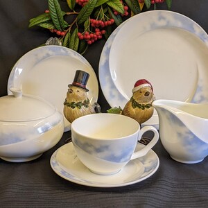 May include: A white porcelain tea set with a blue and white cloud design. The set includes a teapot, creamer, sugar bowl, cup and saucer.