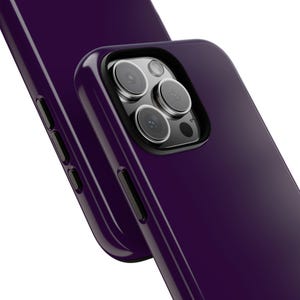 May include: A deep purple smartphone case with a smooth, glossy finish. The case features a precise cutout for the triple-lens camera system, showing the black camera module and lenses. The side edges include integrated black buttons for volume control.