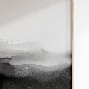 May include: Abstract watercolor painting with a gradient of black and white. The painting features a series of overlapping, layered shapes that resemble mountains or clouds. The background is a light gray, and the foreground is a dark black.