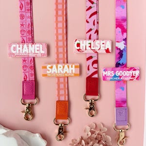 May include: A selection of colourful lanyards with name tags. The lanyards display patterns like chillies and abstract designs. Each lanyard has a name tag with a name and profession, such as "Chanel, Student Midwife" and "Chelsea, Registered Nurse."