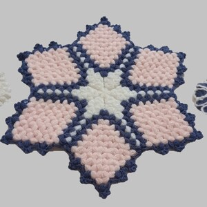 Puede incluir: Tres salvamanteles de ganchillo hechos a mano, con forma de estrella y hexagonal. Presentan hilos blancos, azul marino y rosa claro. Los diseños incluyen patrones geométricos y motivos florales, adecuados para la cocina o la decoración del hogar.