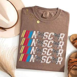 a t - shirt with the words nascar on it next to a pair of shoes