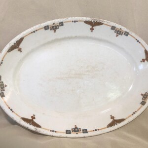 May include: White oval serving platter with a brown and blue geometric design around the edge.