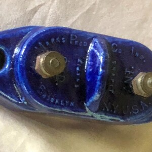 May include: A blue ceramic electrical snap switch with two brass terminals. The switch is labeled "Marks Prod. Co. Inc. Brooklyn, NY USA".