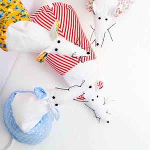 Könnte beinhalten: Drei weiße Stoffmäuse mit unterschiedlichen gemusterten Stoffen auf ihren Körpern. Die Mäuse sitzen auf einer weißen Oberfläche. Die Maus links hat gelben Blumenstoff, die Maus in der Mitte hat rot-weiß gestreiften Stoff und die Maus rechts hat rosa Blumenstoff. Die Mäuse haben schwarze Augen und Schnurrhaare. Das Bild enthält den Text "LemonDIY CRAFTS".