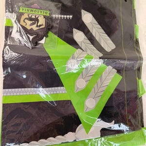 May include: A black and lime green fabric banner featuring a Diasomnia crest patch, a series of white feather-like icons, and a white sword graphic. The banner includes a horizontal lime green stripe and a repeating geometric pattern along the bottom.