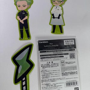 May include: Three stickers featuring characters from the Twisted Wonderland anime. The stickers are green, black, and white. The first sticker is a green-haired character wearing a black uniform. The second sticker is a green-haired character wearing a white lab coat. The third sticker is a green hourglass.