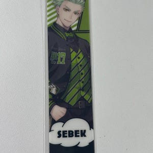 May include: A bookmark featuring an anime-style character with green hair and a black and green outfit. The character is wearing a jacket with the number 17. The name "SEBEK" is displayed at the bottom.