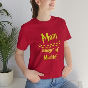 May include: Red t-shirt with a yellow lightning bolt and footprints, and the text "Mom manager of Mischief".