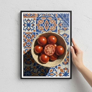 Puede incluir: Impresión enmarcada que muestra una cesta tejida llena de tomates rojos maduros, uno cortado por la mitad. La cesta descansa sobre una superficie de baldosas con patrones geométricos azules y naranjas. El marco es negro.