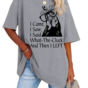 May include: Gray short-sleeved t-shirt with a black graphic of a chicken wearing glasses and a bow. The text on the shirt reads "I Came, I Saw, I Said What-The-Cluck And Then I LEFT."