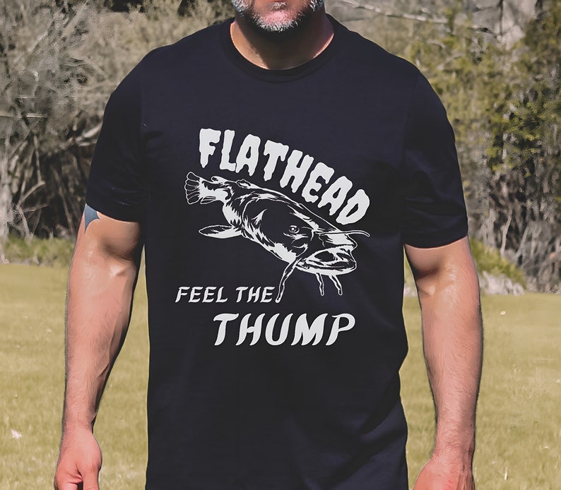 May include: Black t-shirt with a white graphic of a fish and the text "Flathead Feel the Thump"