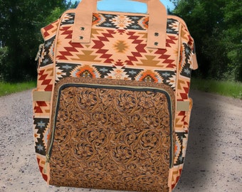 May include: A brown canvas backpack with a geometric pattern in shades of red, orange, blue, and green. The backpack has a large front pocket with a tooled leather design.