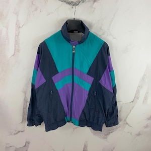 May include: A black, teal, and purple color block windbreaker jacket with a zipper closure.