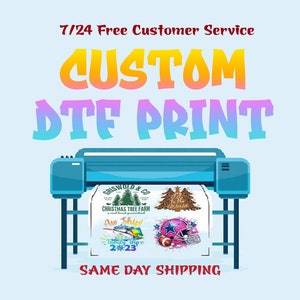 May include: A blue and white printer with a white sheet of paper in it. The paper has several colorful designs printed on it, including a Christmas tree farm, a football helmet, and a phrase that says "Aw Ship!" The printer is on a white background with the text "CUSTOM DTF PRINT" above it and "SAME DAY SHIPPING" below it.
