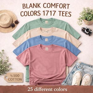 May include: Four blank comfort color t-shirts in pastel shades of green, beige, blue, and pink. The shirts are made of 100% cotton and are displayed with a straw hat, sunglasses, a small plant, a vintage camera, jeans, and sneakers. Text reads "BLANK COMFORT COLORS 1717 TEES".