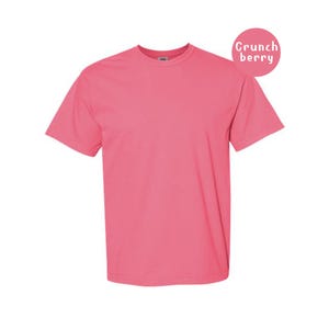 Pode incluir: Uma t-shirt de manga curta em rosa brilhante s&oacute;lido com decote redondo. No canto superior direito, existe um gr&aacute;fico circular rosa contendo o texto branco Crunch berry. A pe&ccedil;a apresenta um corte padr&atilde;o com bainhas nas mangas e na base.