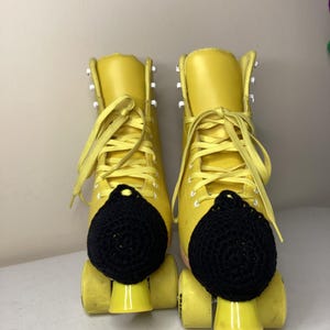 May include: A white ceramic mug with a black handle and the text "But First, Coffee" in a bold, black font. The mug is set against a blurred background, suggesting a cozy setting.