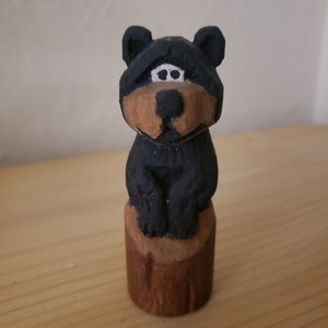 Hand carved bear in a log