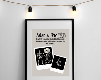 May include: A black and white photo booth sign with a skeleton graphic and the text "SNAP A PIC Help Wolf remember his 2nd birthday party by taking a selfie and leaving a message for him to read."