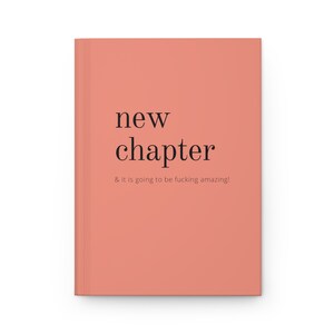 May include: A coral pink notebook with the text "new chapter & it is going to be fucking amazing!" printed in black.