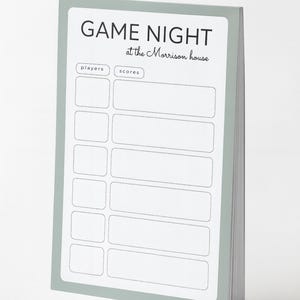Peut inclure: Bloc-notes à bordure vert clair avec l'inscription "GAME NIGHT at the Morrison house" en noir. Il comporte des espaces pour les joueurs et les scores, parfait pour les soirées jeux.