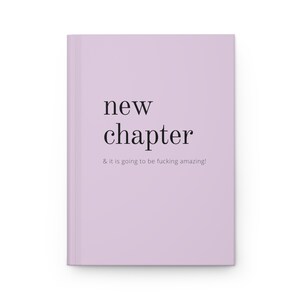 May include: A lavender-colored book with the text "new chapter & it is going to be fucking amazing!" printed in black.
