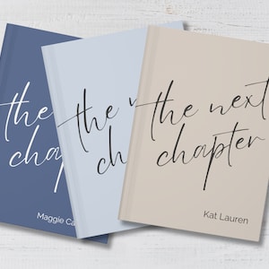 May include: Three hardcover journals with the text "the next chapter" on the front. The journals are in blue, light blue, and beige.