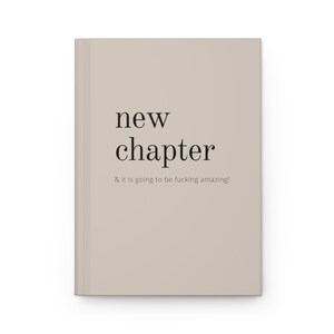 May include: A beige book with the text "new chapter & it is going to be fucking amazing!" printed in black.