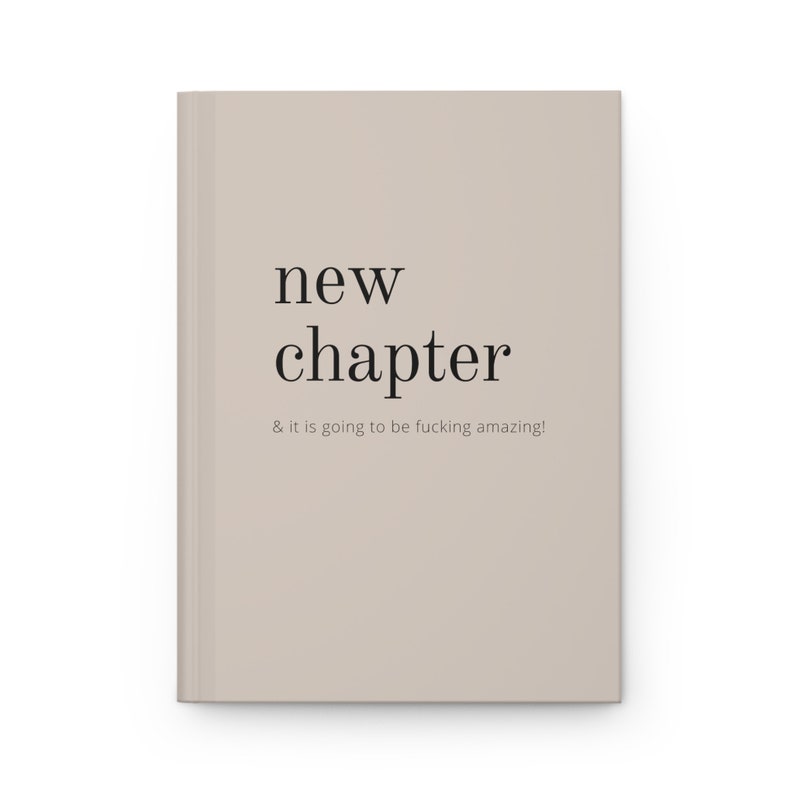 May include: A beige book with the text "new chapter & it is going to be fucking amazing!" printed in black.