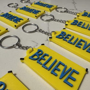 Chaveiro com o símbolo "Believe" | Pingente inspirador com argola para chaves | Presente motivacional | Decoração para fãs de esportes