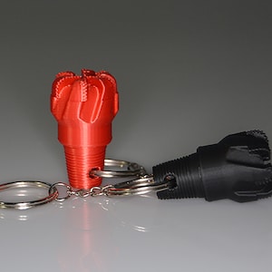 May include: A red and black drill bit keychain. The keychain features a silver chain and two rings.
