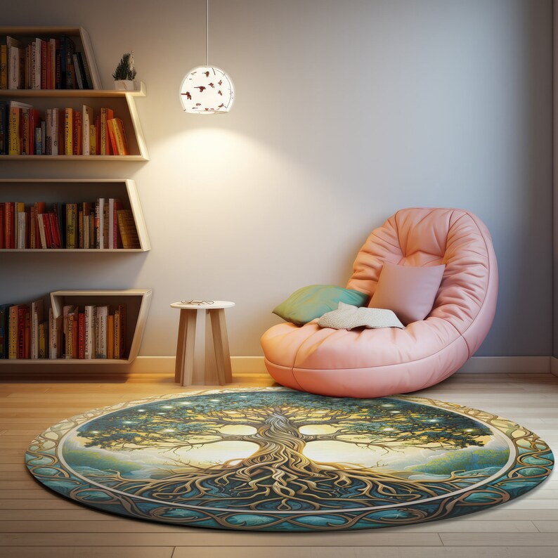 May include: A round, multi-colored rug with a tree of life design. The rug has a light blue background with a green tree with gold roots and branches. The tree is surrounded by a gold circle with a light blue border. The rug is in a room with a pink armchair and a wooden side table.