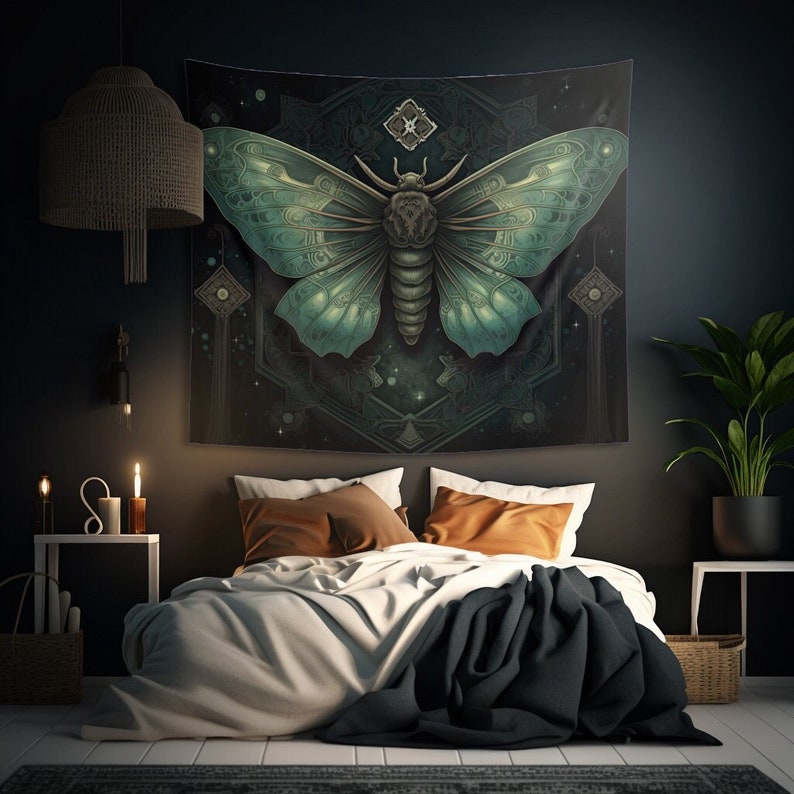 May include: A tapestry featuring a large, intricately detailed, green and blue moth with a geometric pattern in the background. The tapestry is hanging on a dark wall above a bed with brown and black pillows.
