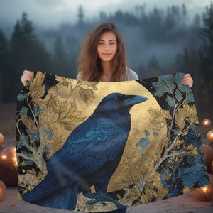 May include: A rectangular textile featuring a large, detailed blue raven perched on a branch. The background displays a prominent gold circular moon motif surrounded by intricate gold and blue foliage patterns against a dark black backdrop.