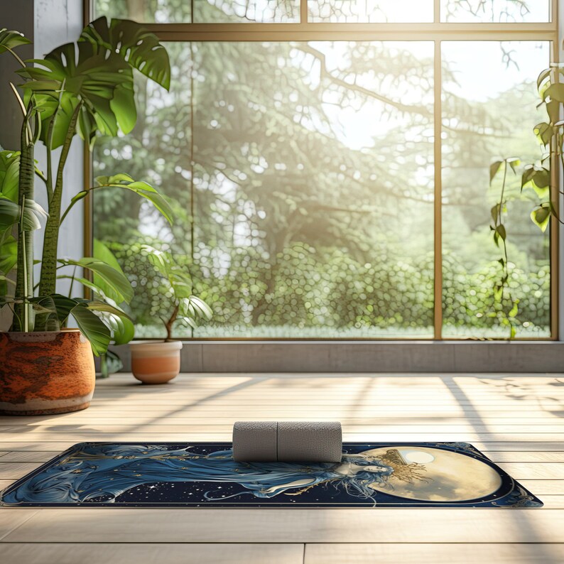 Puede incluir: Una esterilla de yoga rectangular con un dise&ntilde;o celestial azul oscuro, una luna dorada y una figura de cabello fluido, coronada con un peque&ntilde;o rodillo de espuma cil&iacute;ndrico gris, colocada sobre un suelo de madera clara en una habitaci&oacute;n luminosa.