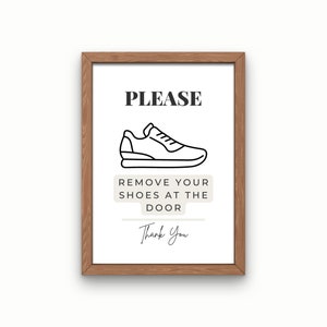 May include: A framed sign with the text "PLEASE REMOVE YOUR SHOES AT THE DOOR Thank You" and a black and white illustration of a sneaker.