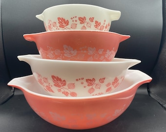 May include: A set of four pink and white mixing bowls with a gooseberry pattern. The bowls are stacked on top of each other.