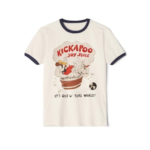 May include: Cream-colored t-shirt with a navy blue trim around the collar and sleeves. The front features a cartoon graphic with the words "KICKAPOO JOY JUICE" in red and a brown barrel with cartoon characters. The text "IT'S OUT O' THIS WORLD!" is below.